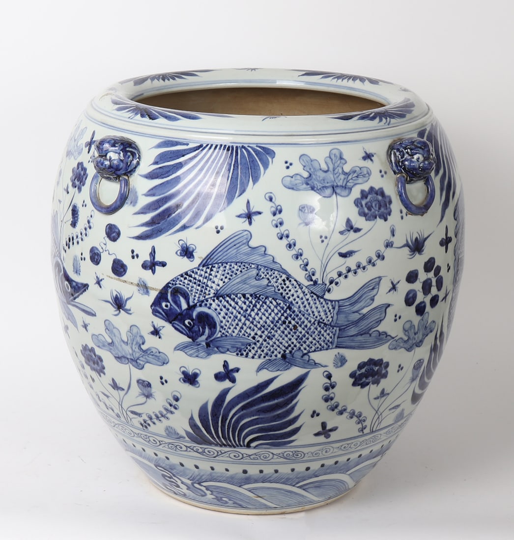 Chinese Blue & White Porcelain Jardiniere: Chinese blue and white porcelain jardiniere featuring molded mask handles, fish under water motif above crashing wave design to foot. Size 20 1/2" H