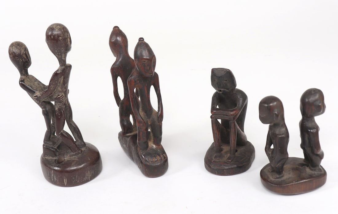 Group of Ifugao Dark Wood Figures: Four groups of Ifugao figures in various poses, one pair bracing each other in their arms, with inlayed eyes. Two pairs of figures are squatted and turned away from each other - similar in style to ol