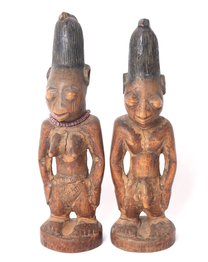 Pair of Ibeji Twin Wooden Figure: Africa, Yoruba Nigeria. Pair of Ibeji wood carved figures with tall hair, necklace to the female, and nude carved features to each. Larger piece 11" H Collected prior to 2008, ex-Lacy Gallery (Vanna &