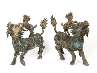 Large Pair of Legendary Chinese Qilin Statues: Large Chinese bronze qilin statues with elaborate details throughout. Each qilin has a smaller qilin riding on top of each other, with wonderfully detailed scales and heavily decorated designs through