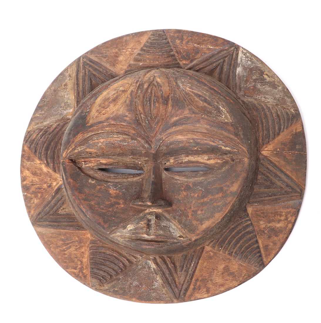 Eket Tribe Wooden Carved Mask: Africa, Nigeria, Ibibio or Eket Tribe carved wooden circular form mask for the trade with a sunburst face and pierced to the eyes. Size 8 3/4" H x 9" W Collected prior to 2008, ex-Lacy Gallery (Vanna 