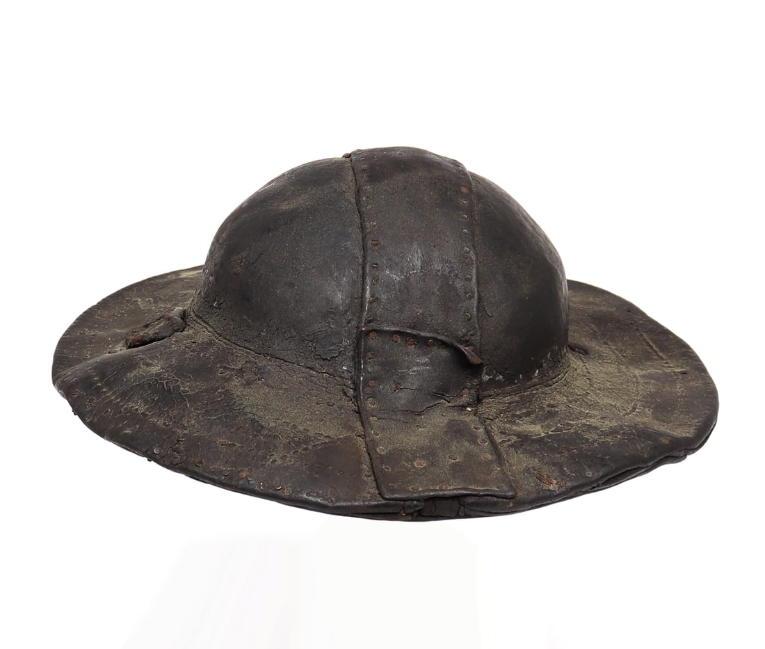 Boiled Leather "Cuir Bouilli" Hat, 19th c.: Boiled Leather or Cuir Bouilli Hat in a heavy and thick leather with old repairs throughout the skull. Boiled leather saw use in many forms for caskets, hats, or leather armour and otherwise from the 