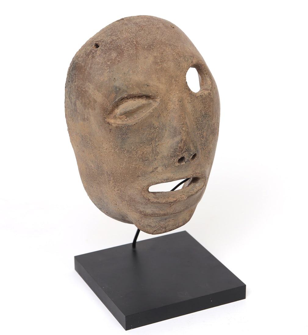 Costa Rican Pottery Transformation Death Mask: Greater Nicoya or Atlantic Watershed, period IV circa 1 to 500 AD. Fine hand molded buff clay, deeply burnished oval mask wonderfully detailed in geometric forms. Exaggerated eye to the right eye, whi