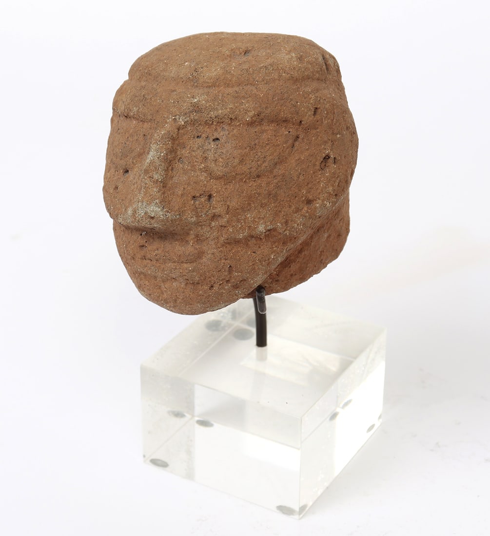 Costa Rican Stone Trophy Head: Atlantic Watershed region, circa 600 to 1000 AD. Hand carved hard stone, depicting a human head with incised almond shaped eyes, small slit lips, and high relief brow. Size 4" H x 4" W, custom lucite