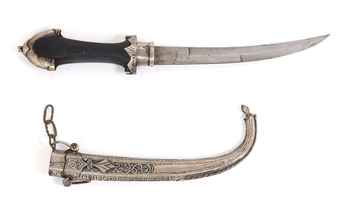 Moroccan Koumaya Dagger: Large Moroccan Koumaya dagger with silver scabbard decorated throughout with scrolling patterns. Blade double edged and slightly curved. Black grip and silvered metal mounts. Size 16" L, blade 8 1/2"