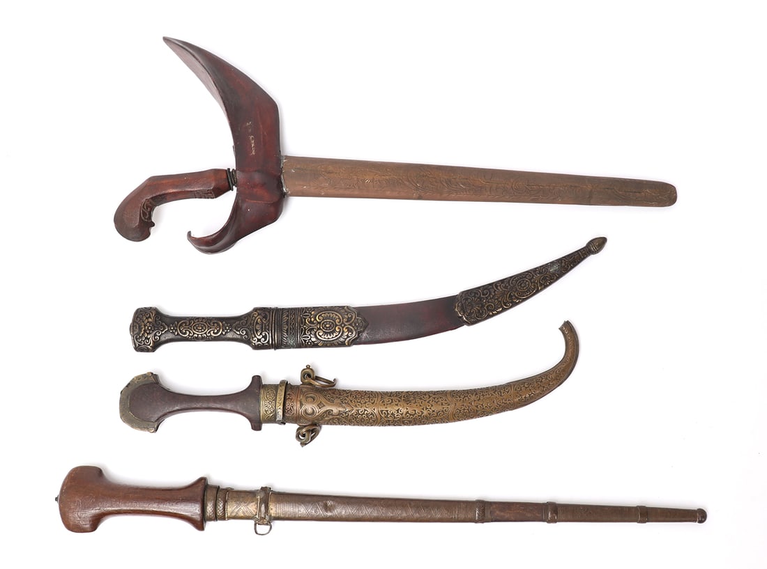 Assorted lot of Daggers: Fine assorted lot of daggers including an all wood kris and matching incised sheath with wavy blade. A rare North African Islamic straight blade Genoui with brass scabbard. A polished bright bladed Kh