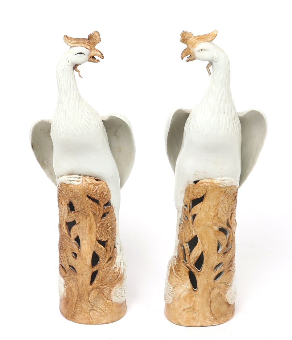 Gorgeous Pair of Chinese Porcelain Phoenix Statues: Fine pair of Chinese porcelain phoenix statues, each depicted stationary on flower covered rock pedestals, with pierce work throughout. Each bird with long flowing tails, pure white feathers and golde