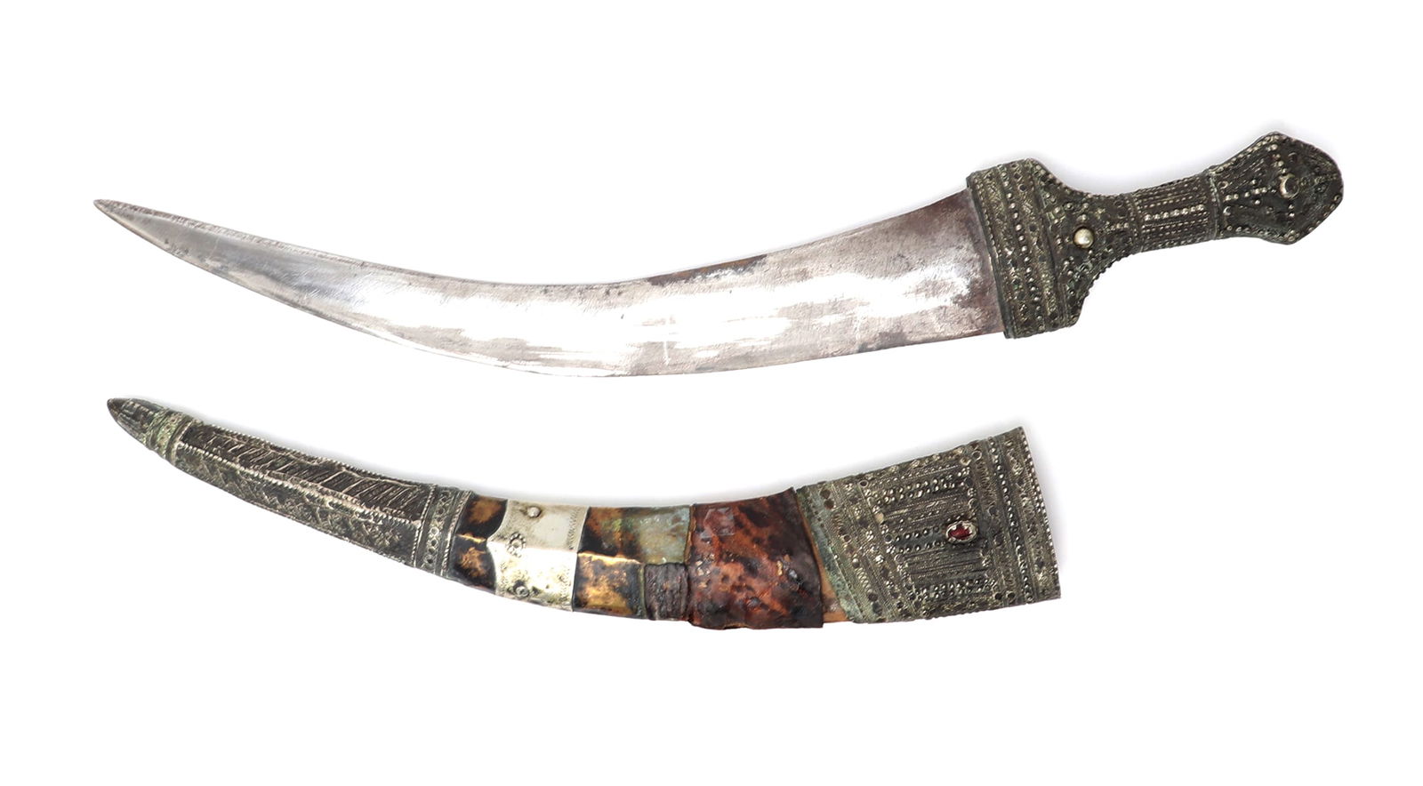 Islamic Silver Dagger w/Scabbard: West Asia, Arabian Peninsula, Wahhabite silver mounted jambiya dagger with scabbard, late 19th century. Handle in silver panels to the face with decorative raised detailing. Blade a curved double edge