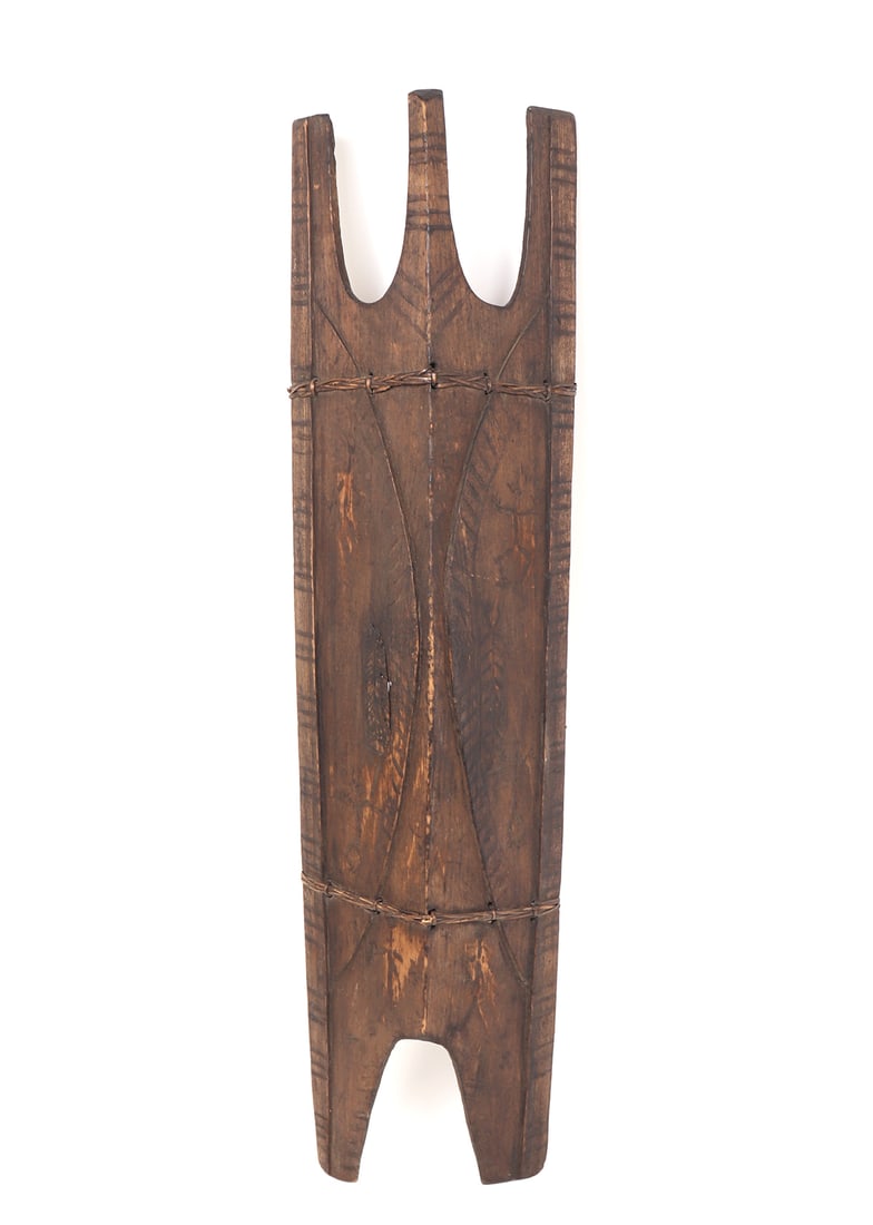 Filipino "Kalasag" War Shield, Bontoc Peoples 19th C.: Philippines Archipelagos, Northern Luzon, Cordillera mountain range, Bontoc / Bontok Igorot Peoples 19th or early 20th century. Full body wood carved shield in faded black with rattan wrapping in hori