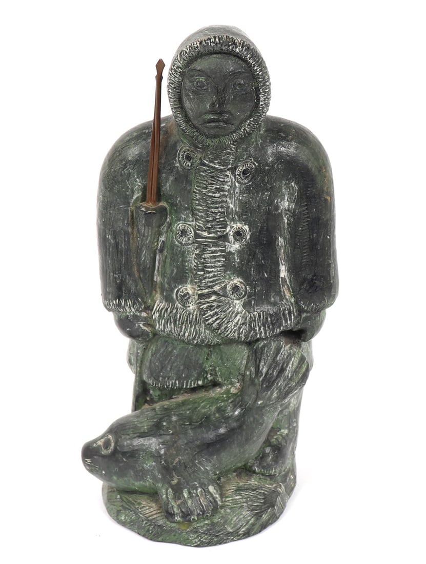 Wolf Original, Figure with Sealion: Cast green composite, depicting an Eskimo with a seal pup. The Eskimo stands wearing his traditional parka, pants and mittens made from caribou or sealskin. He holds two metal harpoons, with a very ge