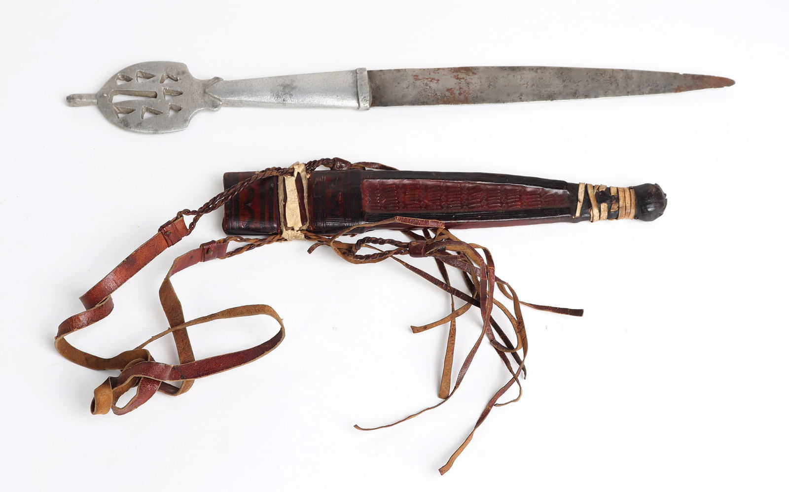North African Knife w/Sheath, 20th C.: North African knife with sheath, slender double edge blade with silvered grip and pierced. Leather sheath with ebony, red, tan leather in bands wrapped around one another, and handing tassels. 10" D.