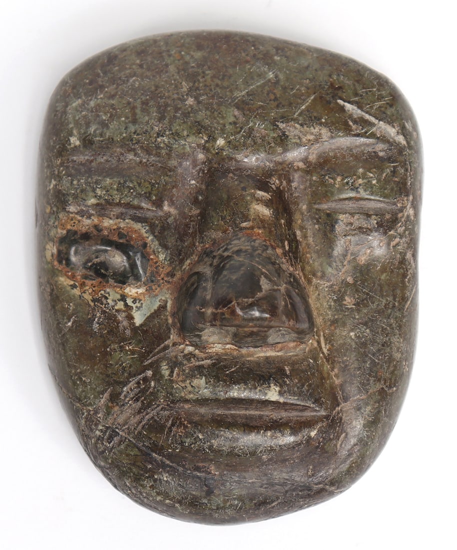 Olmec / Olmecoid Mask greenstone, 900 - 600 BCE or Earlier: Pre-Columbian, Mexico and Guatemala Territories, Olmec 900 - 600 BCE or Earlier. Green mottled stone mask with great signs of wear from age and use including a somewhat misshapen head, wide eye featur
