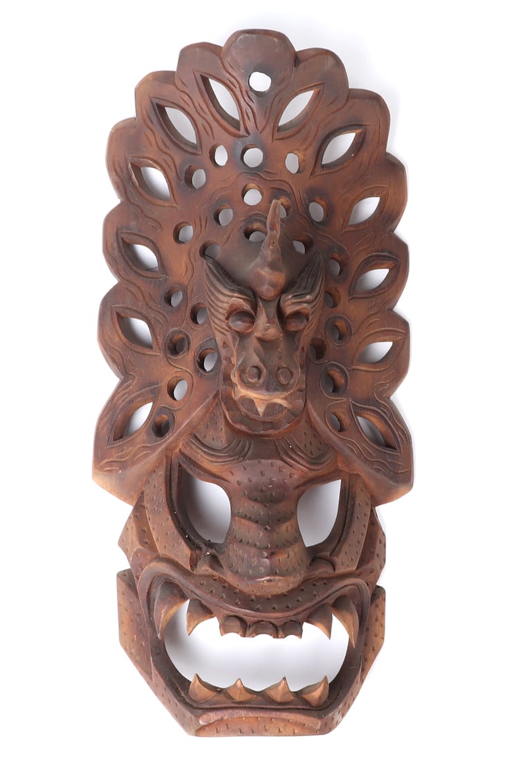 Filipino Bakunawa Wood Carved Mask: Carved from a single piece of heavy wood, this intricate Filipino mask in the shape of an intimidating demon with dragon headdress. Wood is caramel and maple colored throughout with jagged teeth and m