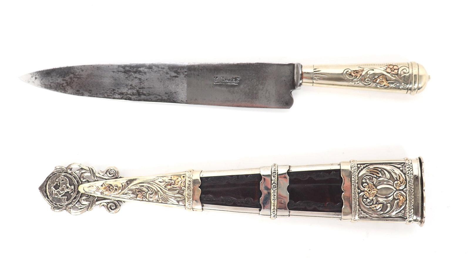 Massive Presentation Silver & Gold Gaucho Knife w/ Sheath: South America, Argentina. Silver and gold presentation gaucho knife in massive proportions. The scabbard with open panels exposing an interior of tooled leather as well as pierced openwork silvered pa