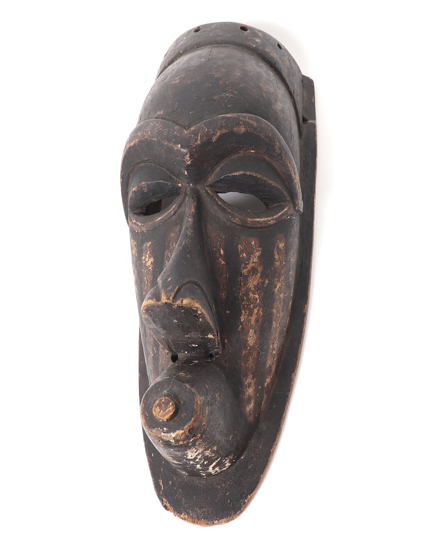 African Carved Wood "Kete" Mask, Kuba Kingdom: Central Africa, Kuba Kingdom and peoples, Kete group carved wood dance mask. Ebonized black carved wood mask in elongated form with a defined brow, large nose, and circular mouth. The cheeks with stri