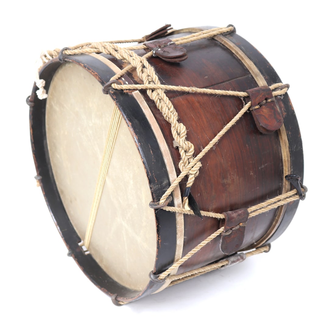 US American Civil War Drum: U.S. American Civil War period snare drum with a series of tension ropes and leather tensioners. Top with original face and intact. An elongated metal loop to one side Size 11 1/4" H, 16" W
