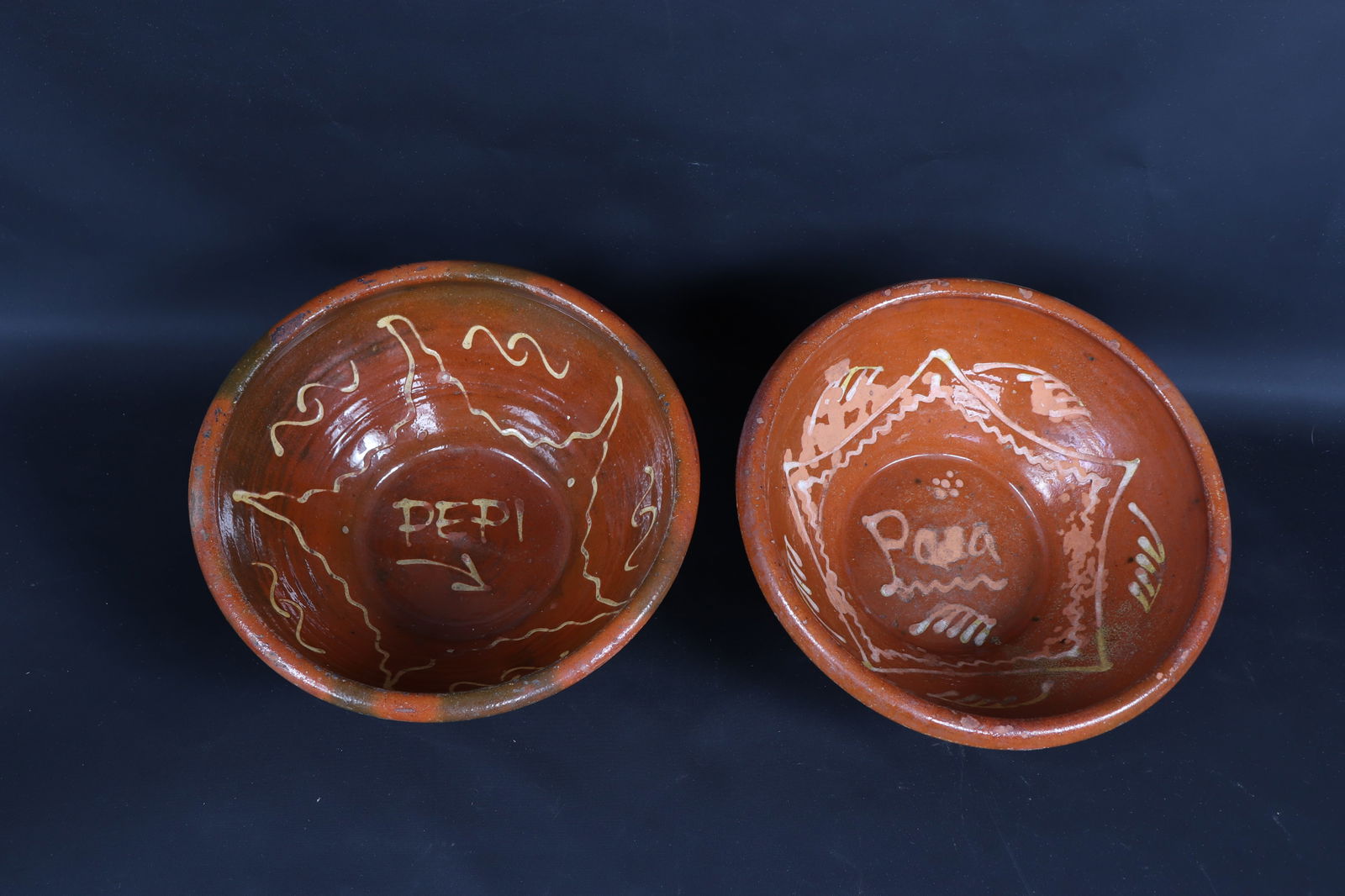 Two French Terracotta Redware bowls, 19th C.: 19th century two French red slip glazed bowls with applied painted designs to interior reading 'Pepi' and 'Pasa' 10.25" W x 3.75" H