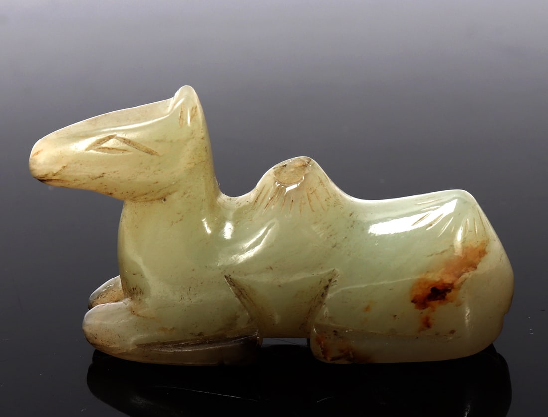 Chinese Miniature Jade Camel Pendant: Chinese miniature jade pendant of a young camel, in a recumbent pose with incised pyramid shaped eyes, incised hump and tail details as well as hooves. Lovely testament to attention to detail and craf