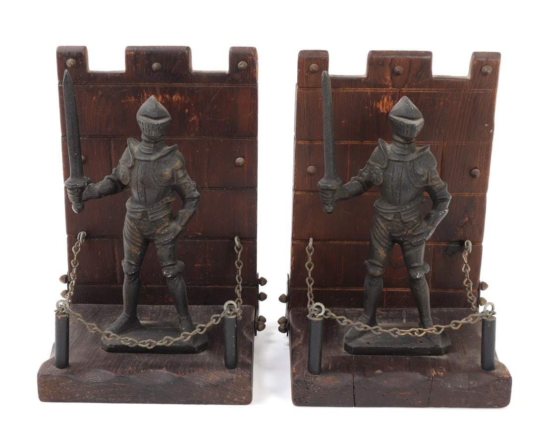 Pair of Armour Knight Bookends: Pair of armour knight bookends crafted from dark-stained wood and metal. These medieval-inspired pieces feature detailed knight figures clad in full armor, each holding a sword. The wood backplates ar