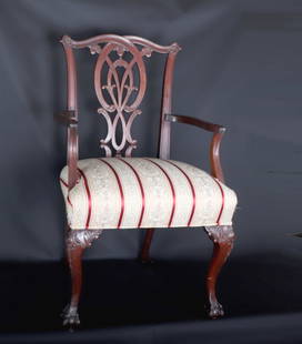 Antique Mahogany Chippendale Arm Chair: Antique mahogany Chippendale arm chair with replaced cushion upholstery. Heavily interlaced and pierced back with carved wood corners and joints, curved and claw footed legs to front. 40" H x 23 3/4"