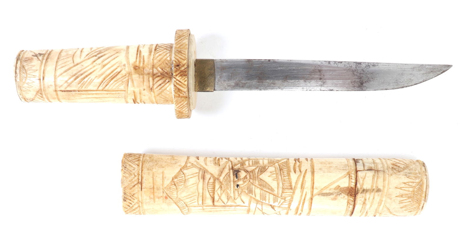 Japanese Bone Tanto Dagger: A finely crafted Japanese tanto-style dagger, likely dating to the mid-20th century. This unique piece is composed of intricately carved bone, featuring a detailed engraved scene that wraps around bot
