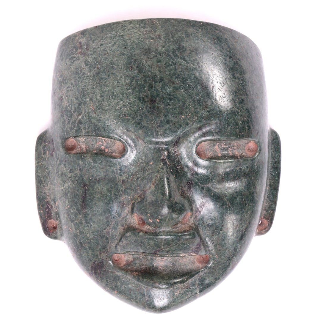 Pre-Columbian Jade Stone Mask: Pre-Columbian Jade hardstone mask of a transformative face with large upper lip and cinnabar highlighting to drilled sections. Drilled to the ear lobs with conical drilling to either side. Drilled to 