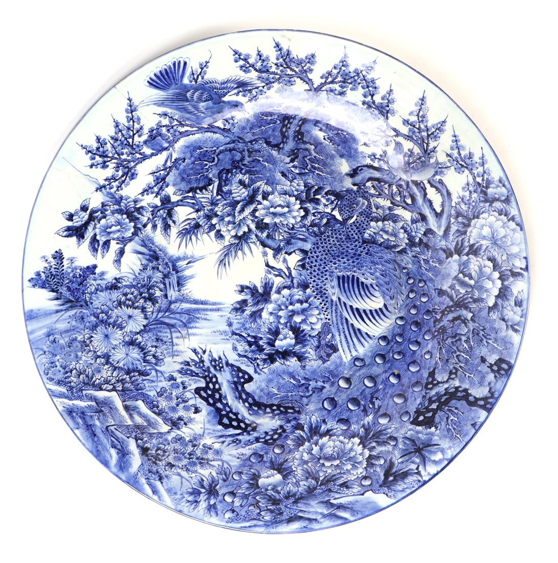 Large Japanese Porcelain Blue & White Charger: Beautiful large Japanese porcelain charger features intricate floral and avian motifs, including a large handsome peacock in the foreground along the river. Chrysanthemums and other blooming flowers t