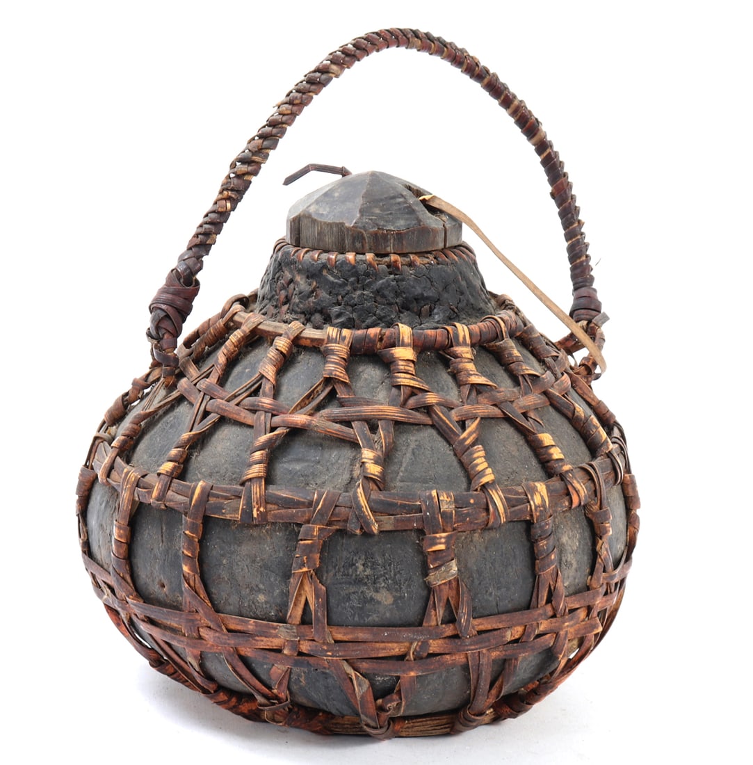 Antique Filipino Canteen, Coconut & Rattan: Handsome large coconut hollowed out and turned into a water canteen with braided rattan handle, and woven rattan around the body for carrying. Custom wood stopper affixed to the top. Size 7 1/2" H