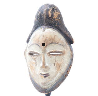 Wood Carved African Punu Mask: Wood carved Punu mask from Gabon. Hand carved wood mask featuring a tall hair style with slit eyes, small pout lips and small protruding triangular nose. Historically, they were worn by men on stilts