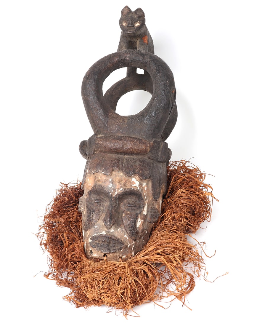 Ibo Helmet Mask w/ Animal Crest: West Africa, Nigeria, Igbo (ibo) peoples helmet mask with mane and a double loop animal crest finial depicting a lion. Constructed of wood, pigment and plant fibers with a ritual applied patination wh