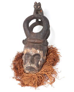 Ibo Helmet Mask w/ Animal Crest: West Africa, Nigeria, Igbo (ibo) peoples helmet mask with mane and a double loop animal crest finial depicting a lion. Constructed of wood, pigment and plant fibers with a ritual applied patination wh