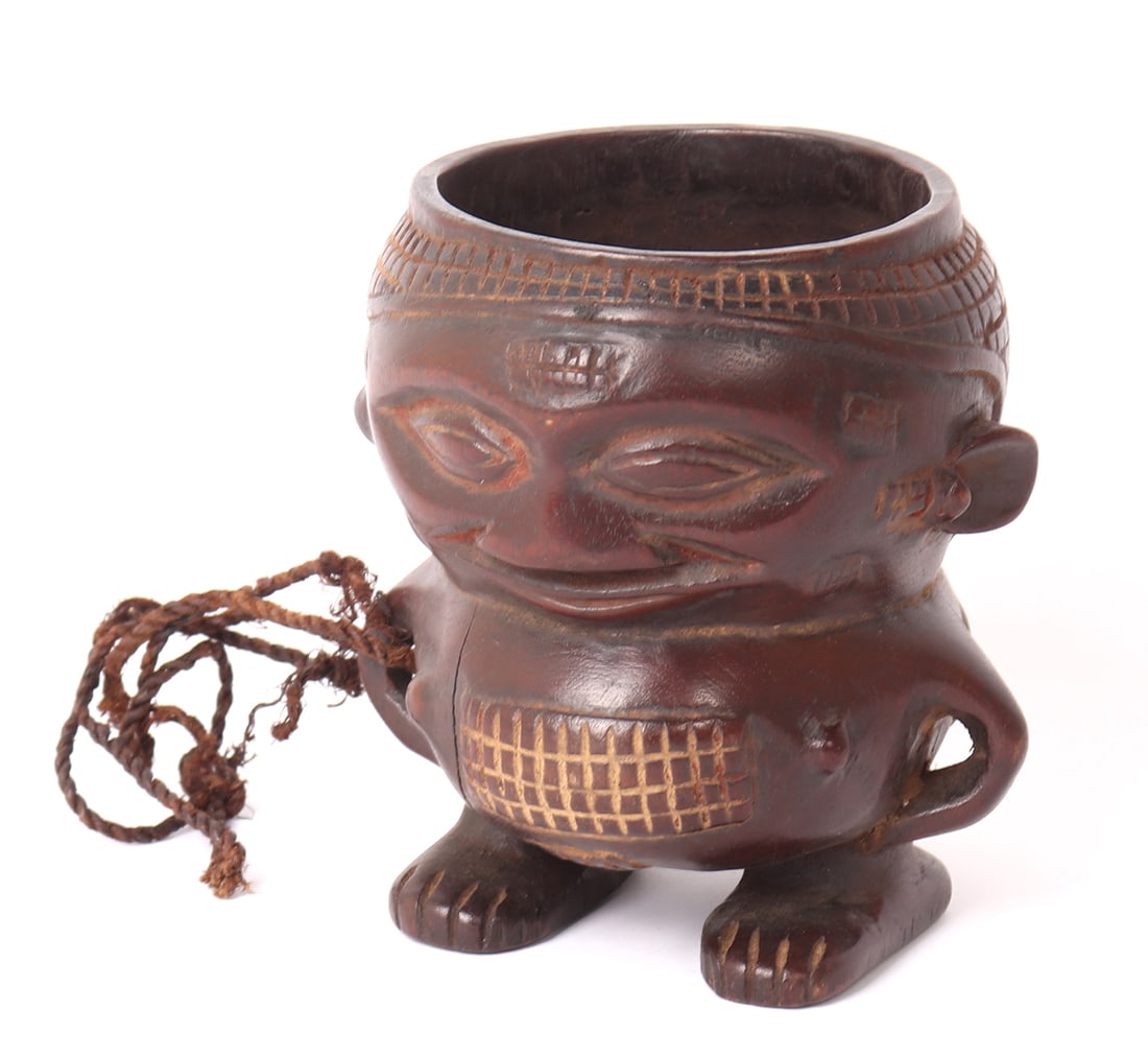 African Kuba Wine Cup: Central Africa, Democratic Republic of the Congo, Kuba Peoples. 20th century Kuba cup carved in the form of a miniaturized human with detailing to the feet and crosshatch patterns to the bell and hair