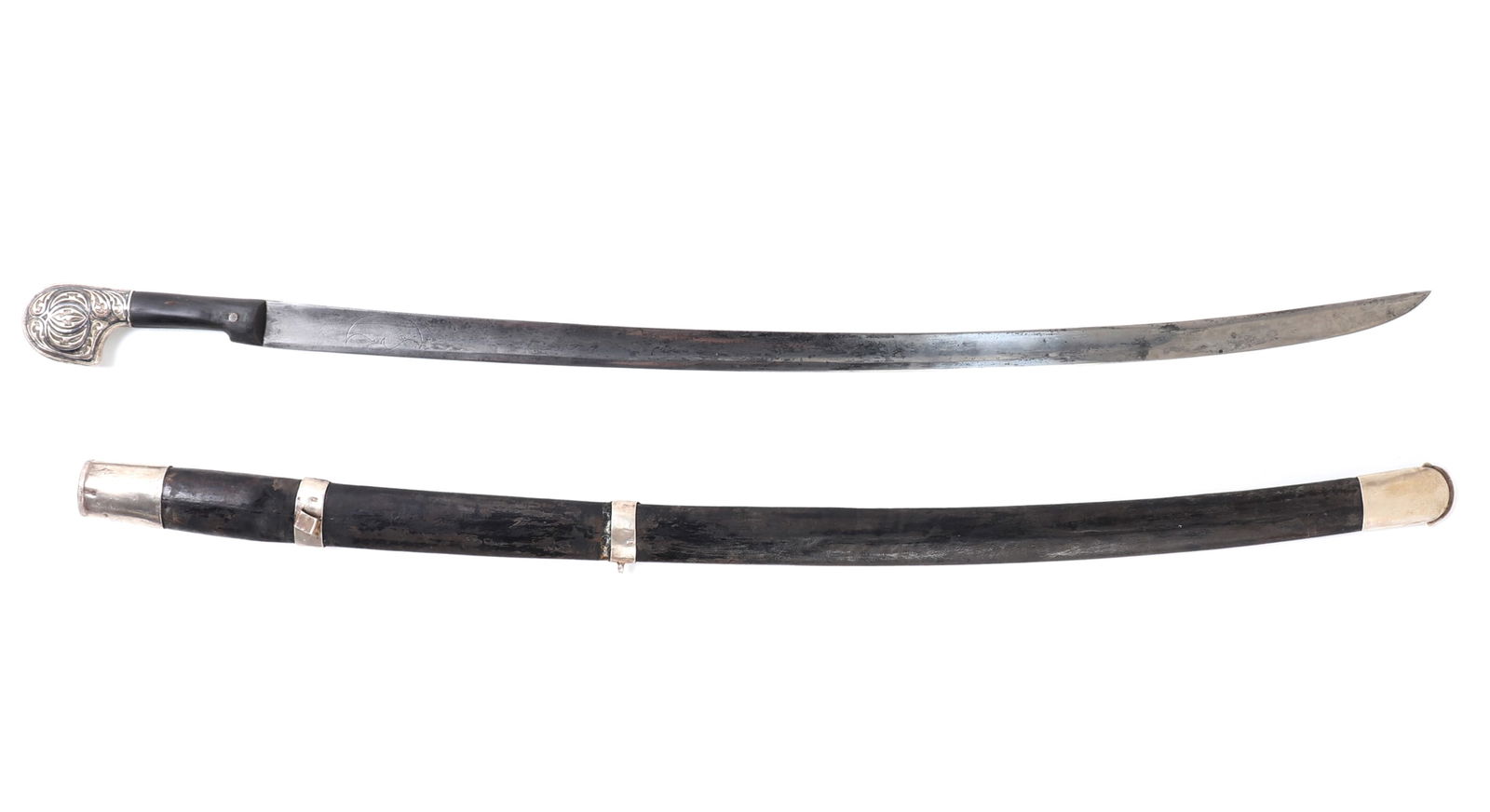 Caucasus Shashka Sword and Scabbard: Caucasus region Shashka sword with leather scabbard with a guard less horn carved hilt with silvered fittings. Single edged slightly curved blade, designed for unhindered cutting from horseback. Silve