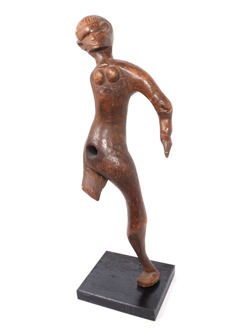 Makonde Abstract Female Statue, Tanzania: East Africa, Tanzania, probably Makonde style abstract female figure mounted on custom stand. Contorted legs with a buckled knee and one leg missing. The female figure with one arm. Size: 37 1/8" H (i