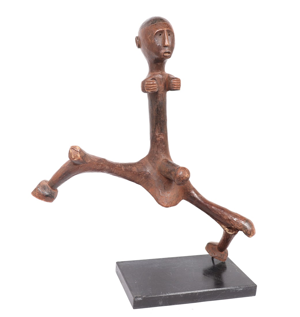 Makonde Abstract Male Figure, Tanzania: East Africa, Tanzania, probably Makonde style abstract male figure mounted on custom stand. Figure stands in expressive pose. Elongated and contorted legs with protruding knees contrast with almost ab