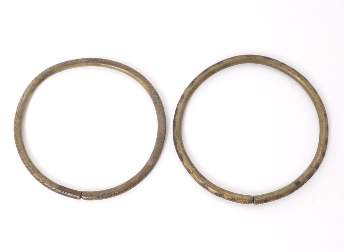 Pair of Filipino Brass Bangle Bracelets: Lovely pair of incised bangles from the Philippines. One with banded lines and the other with geometric incised designs throughout. Size largest bracelet 3 3/8" W