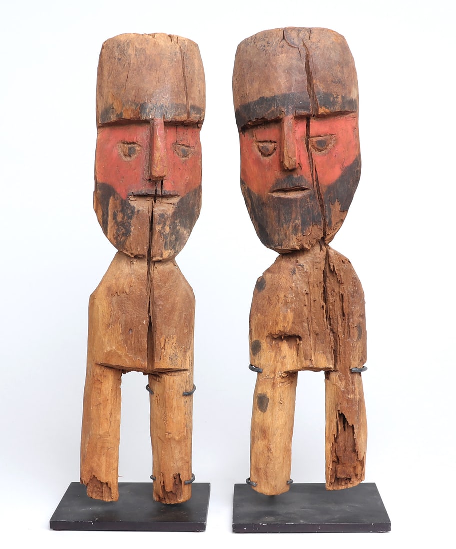 Pair of Chancay Wood Standing Figures: Finely carved pair of Chancay wood figures. Each with painted red pigment faces, and remains of black pigment as beard and hair. Protruding noses with inset cheeks and eyes, incised in almond shapes. 