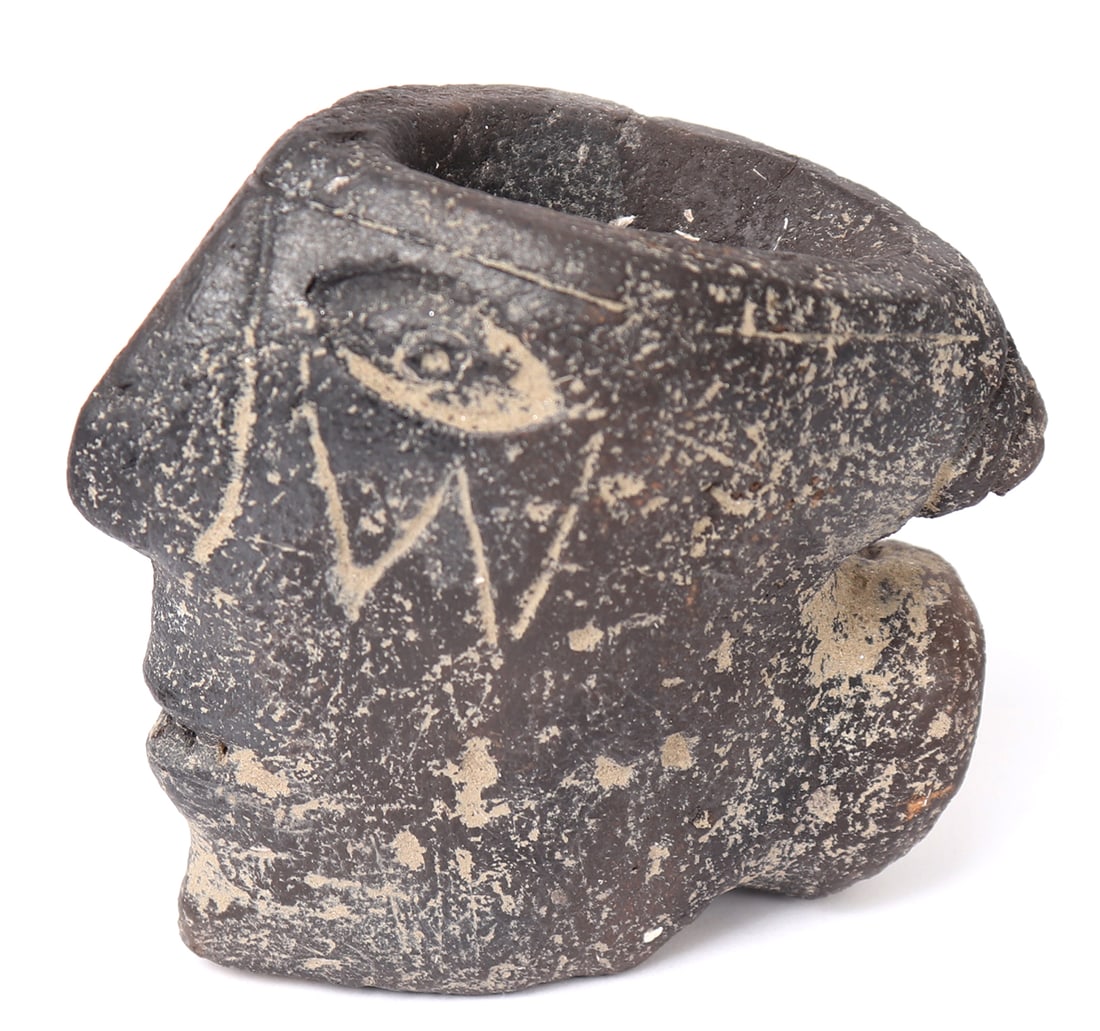 Mound Builders Terracotta Tobacco Pipe, 800 - 1200 CE: North America, Native American, Mound Builders 800 - 1200 CE terracotta tobacco or smoking pipe in the form of a male painted face. Piece features brownish black coloration featuring a detailed mouth