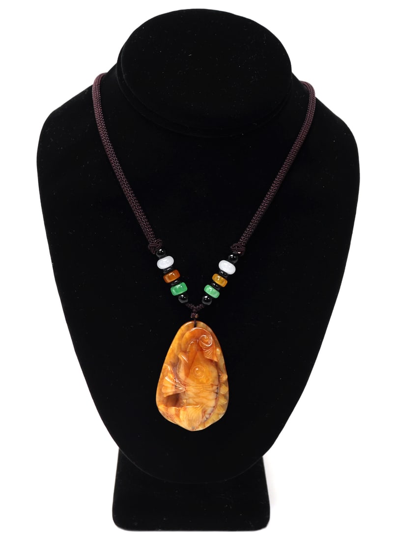 Chinese Jade Koi Fish Pendant: Lovely amber colored Chinese jade koi fish pendant, suspended on a cord with interchanging colored beads. Pendant is expertly carved with fine detail throughout. Size 25" L, pendant 2 1/8" L