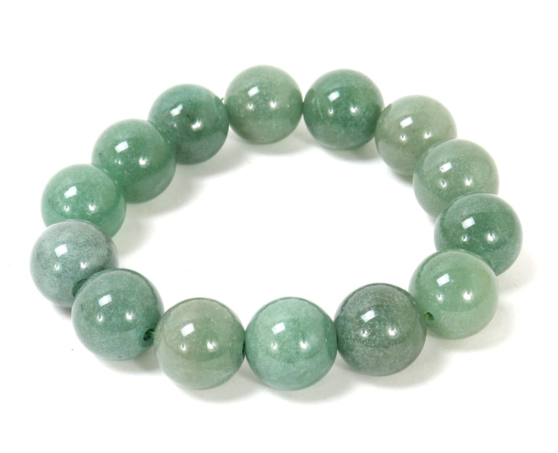 Gorgeous Chinese Jadeite Beaded Bracelet: Fourteen beautiful Chinese light green jadeite beaded bracelet all finely polished throughout with varying colors from a dark shade of green to light green throughout. Size 3" W, elastic band