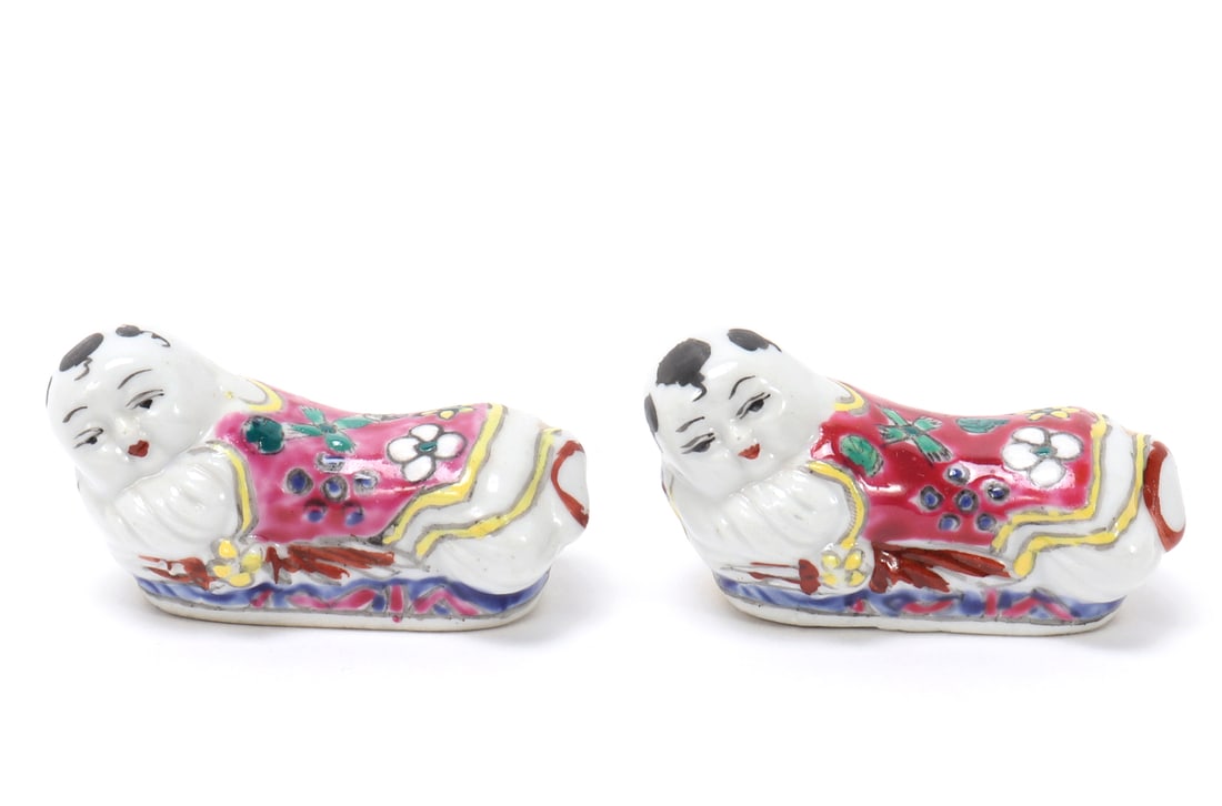 Pair of Baby Monk Brush Holders: Adorable pair of Chinese porcelain baby monk desktop brush holders. Each depicted on their belly with bright smiling faces and pink robes with flowers throughout. Size 2 3/8" L