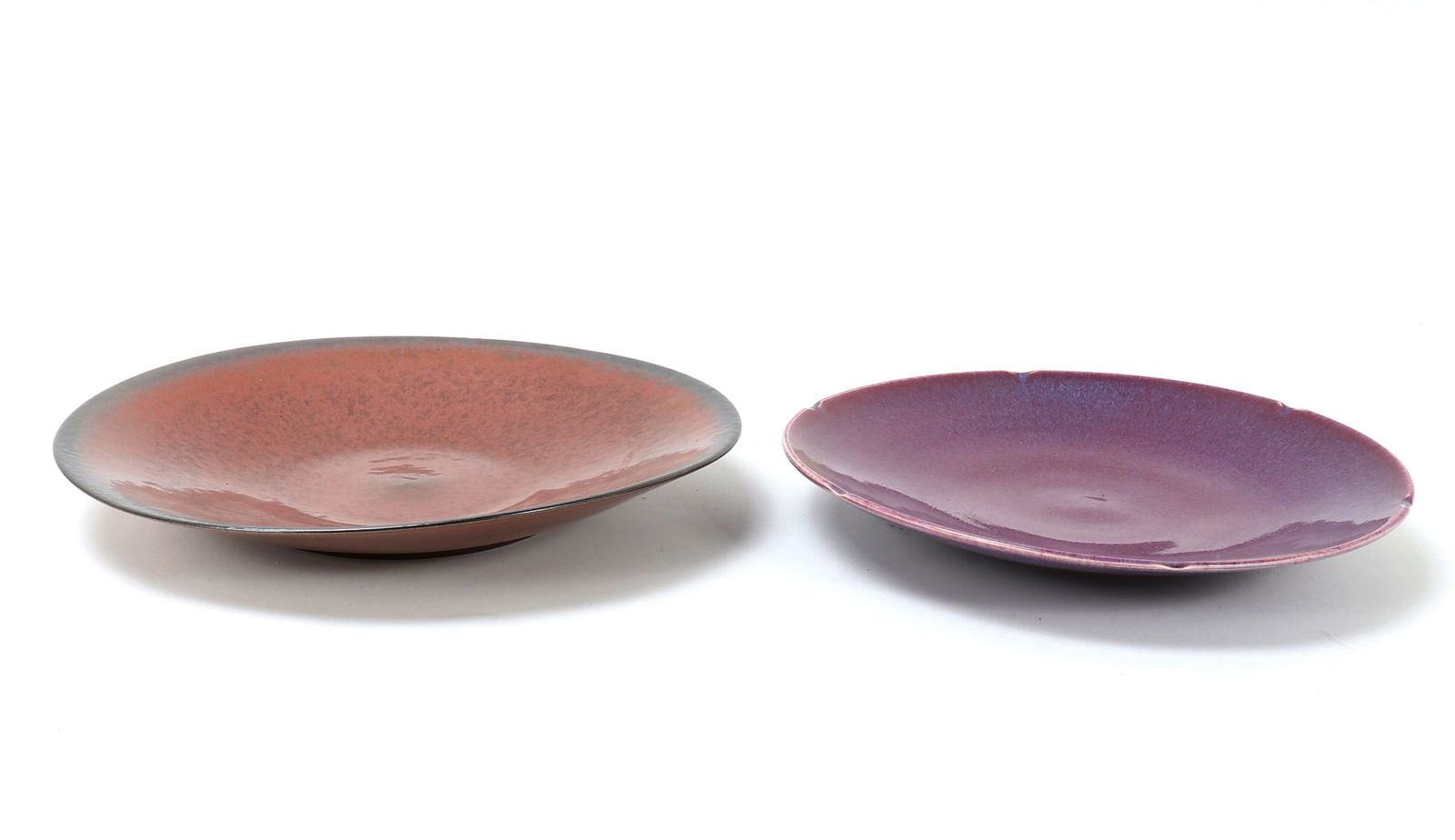 Two Chinese Porcelain Glazed Plates: Two beautiful Chinese porcelain glazed plate, one in a lovely burnt orange and the other in a deep lovely purple. Size 15 1/8" W