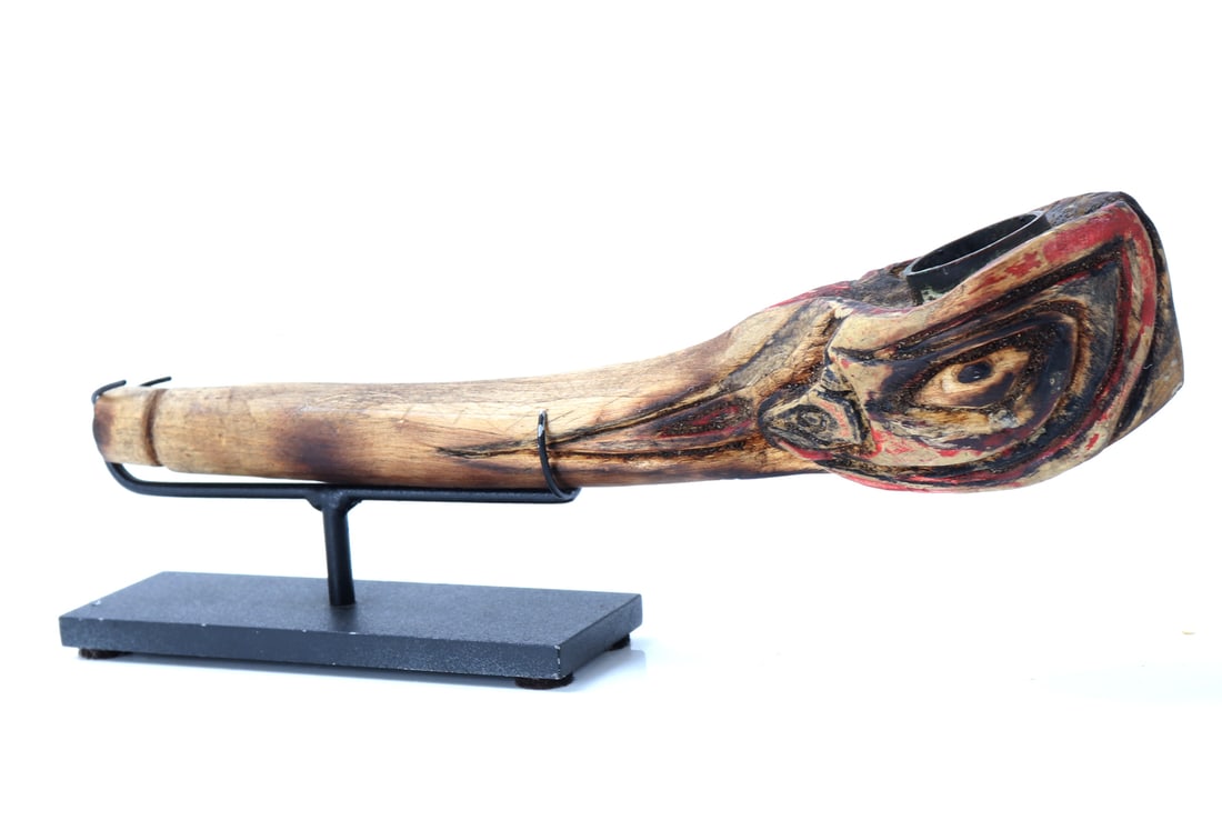 Antique Native American Carved Pipe: Pacific Northwest region, a striking piece of craftsmanship, this antique Native American pipe is intricately carved and displays a patina indicative of age. The carving features bold, expressive