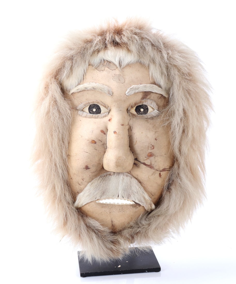 Wonderful Inuit Caribou Hide & Fur Mask w/Stand: Handsome large Inuit mask comprised of caribou hide and likely wolf fur, reinforced with a rounded wood frame. Almond shaped eye with added black pigment detail. Mouth slightly open with a bushy