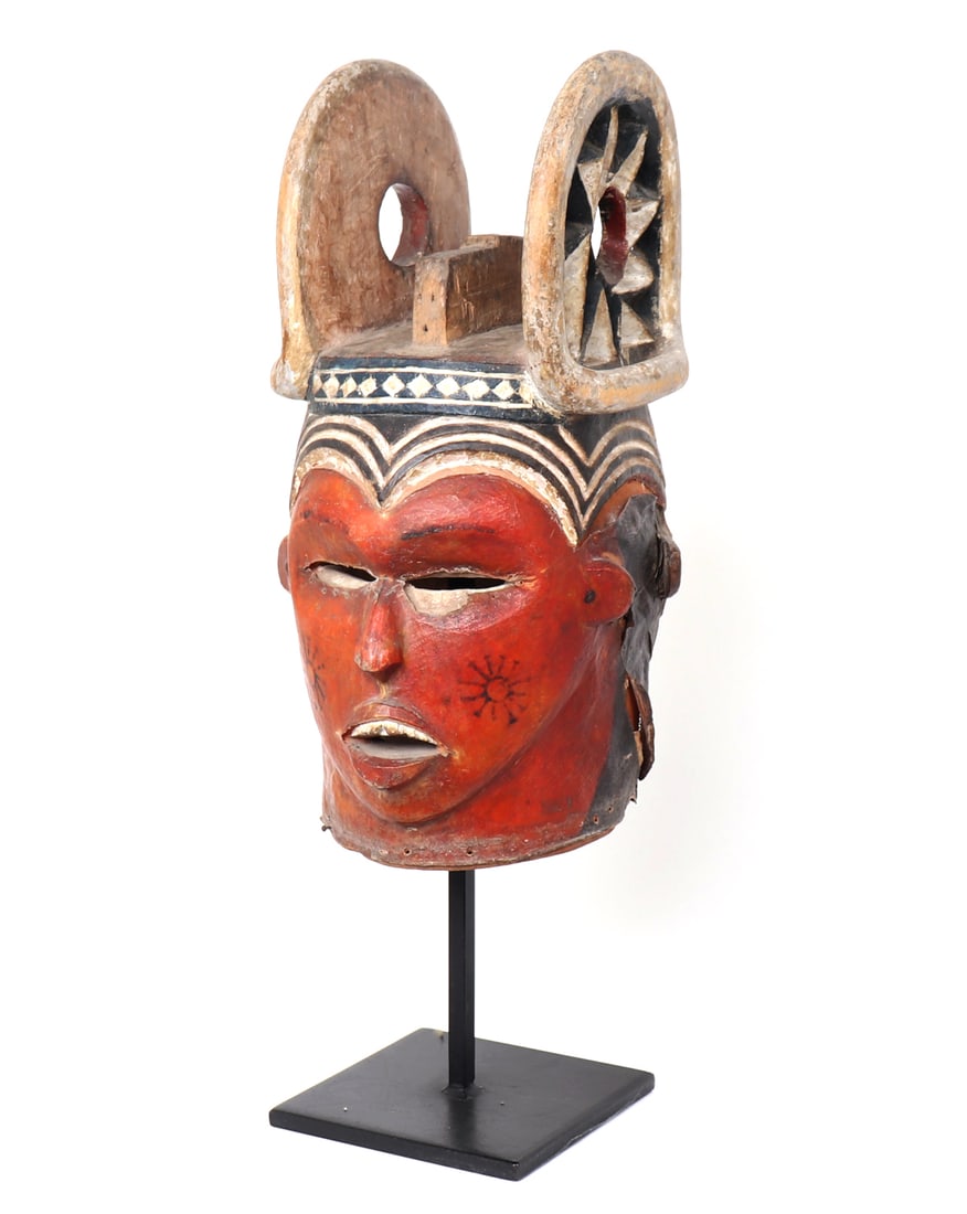 Igbo Horned Janus Helmet Mask, Nigeria: Nigeria, Igbo peoples. Horned Janus mask carved in wood and wrapped in leather painted in pigment. Leather wrapped with two opposing faces in the Janus fashion with one in red and another in white. Ca