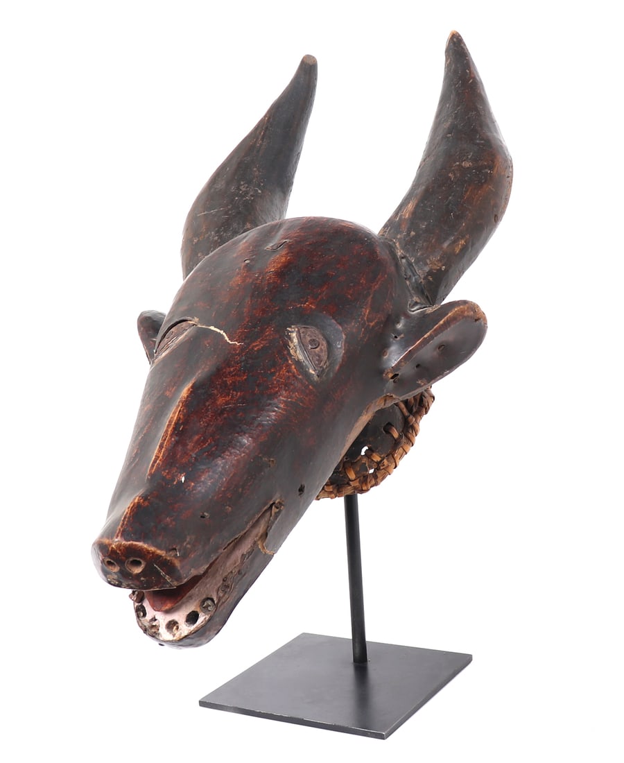 Exceptional Antelope Headdress, Ejagham peoples: Nigeria, Ejagham peoples. Exceptional African hand carved wood antelope headdress, covered in stretched pigmented red skin. Incised eyes with metal inlays. Mouth agape with teeth that remain showing,