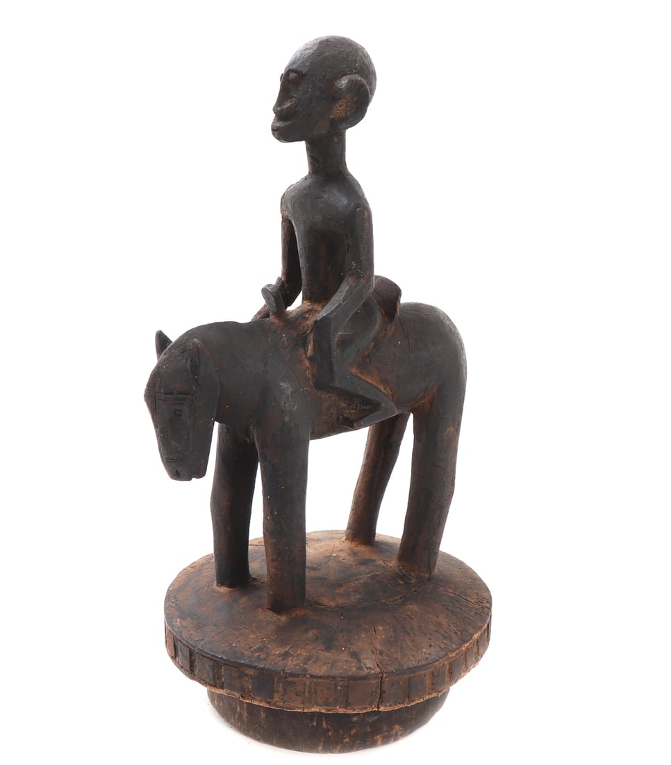 African Wood Carved Horse & Rider Lid: African wood carved lid for a storage vessel with a man riding a horse on the top. The figures are both carved in minimalist style with smooth features throughout. Size 11 3/4" H x 6 3/4" WCollected