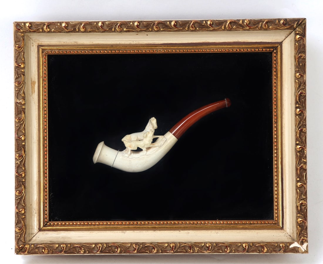 Framed Bone Carved Pipe, Horse & Dog: Handsomely crafted bone carved pipe with a maple wood looking body and mouth piece. Depicted on the top is a dog chasing after a horse, either each out running wild or a herding dog. Size 9 7/8" L x