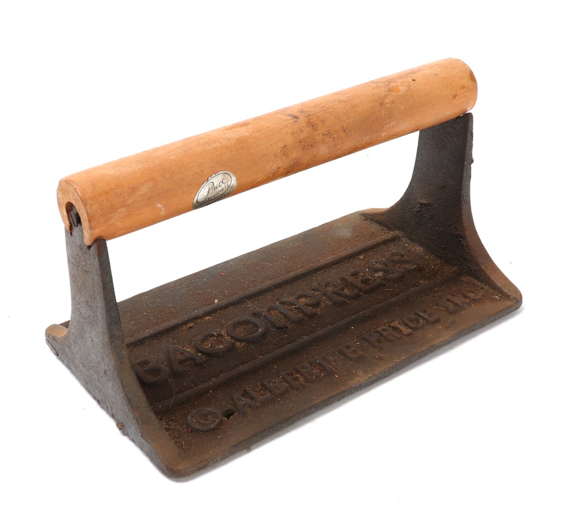Cast Iron Bacon Press: Vintage cast iron bacon press with wood handle and stamped surfacing reading (BACON PRESS, Copyright Albert E. Price Inc.). Underside of the press with smiley face suns, bacon and eggs, and three