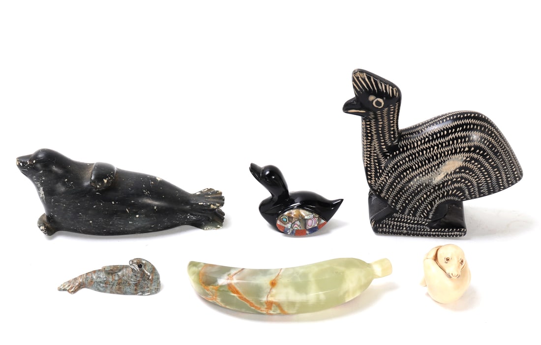 Group of Six Various Stone & Wood Carvings: Lovely group of carvings including two sea lions, a jade style banana, onyx with mother of pearl applied duck, wood avian carving, and lastly "Cyril" Roly Poly trinket box from Harmony Kingdom,